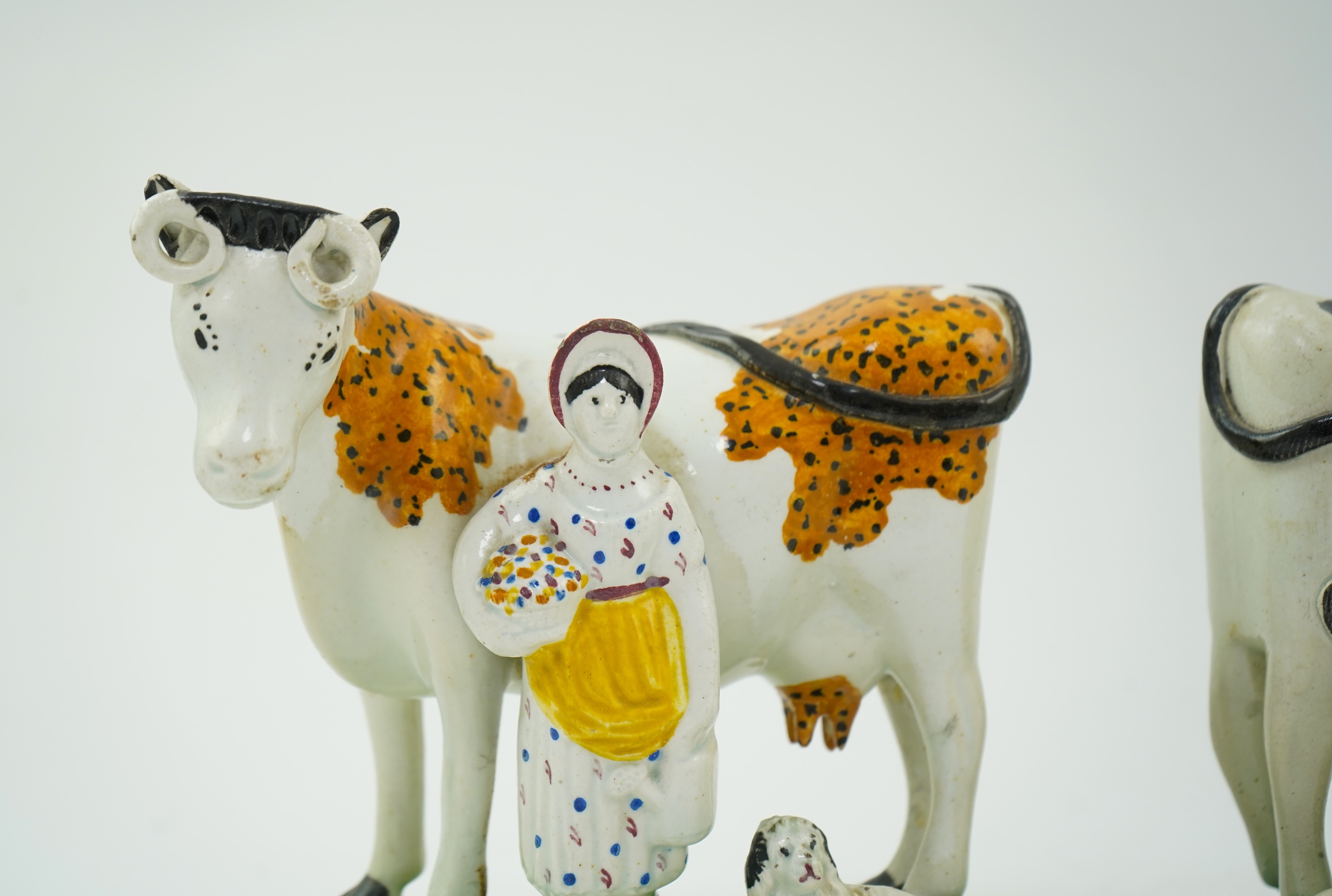 Two Yorkshire Prattware cows, with farmer or milkmaid and dog groups, c.1810